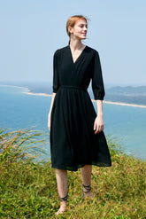A woman wearing a long black dress on the grass